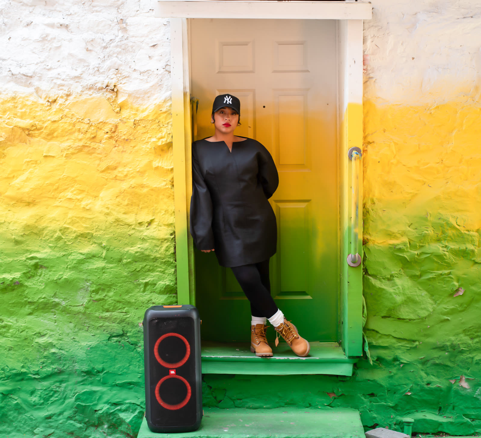 Bella Veronica standing in a doorway painted yellow and green.